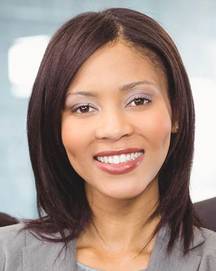 a woman in a gray shirt is smiling at the camera.